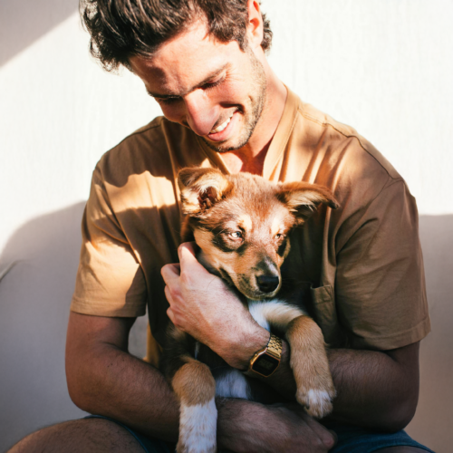 Man cuddling dog