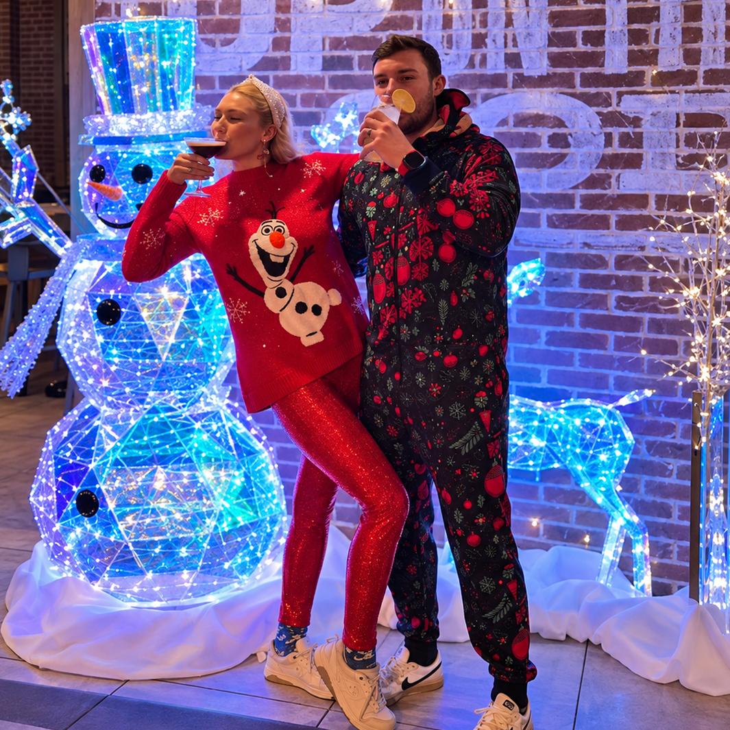 Cute couple with a lit snowman and decor at Elf'd UP