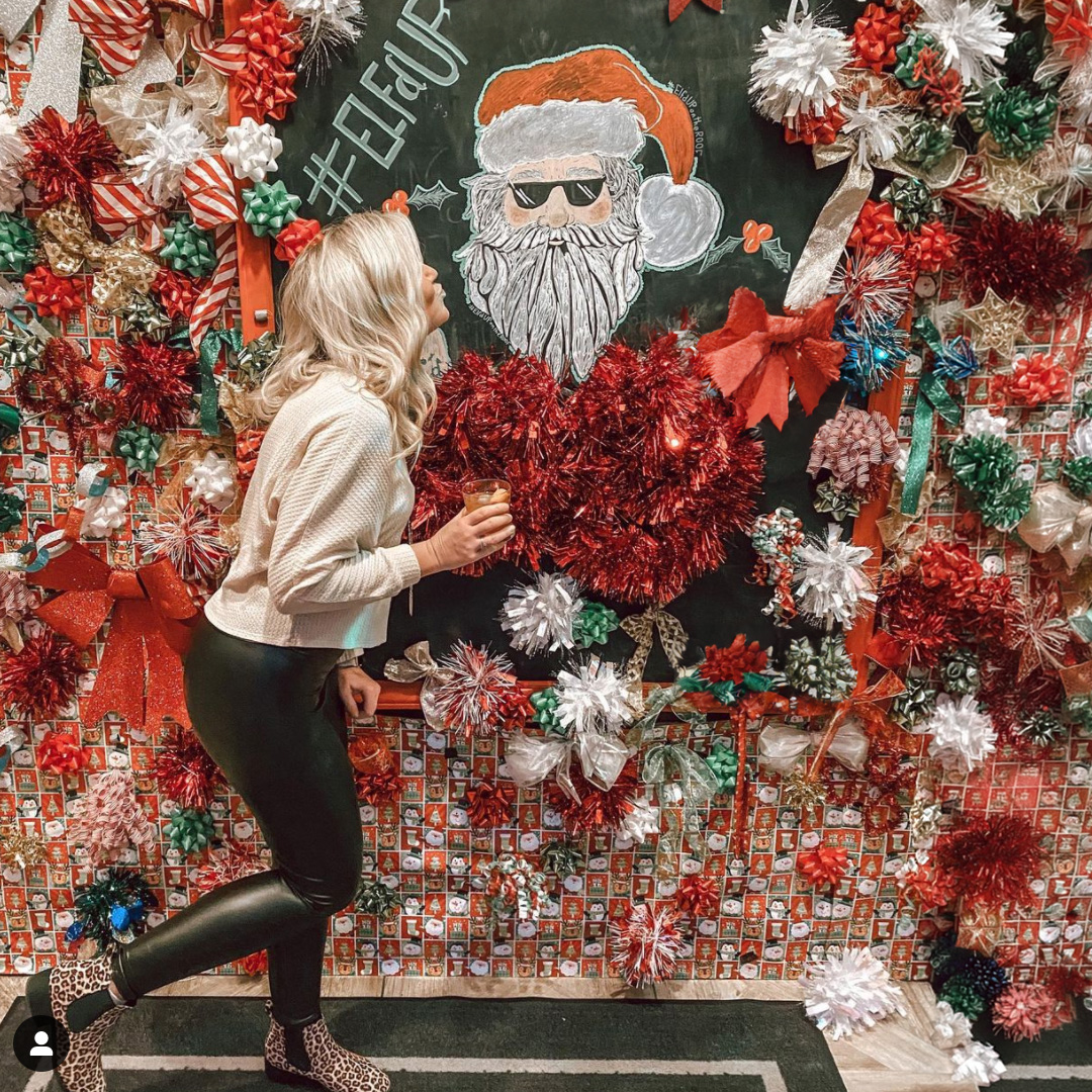 Woman in front of the Santa wall