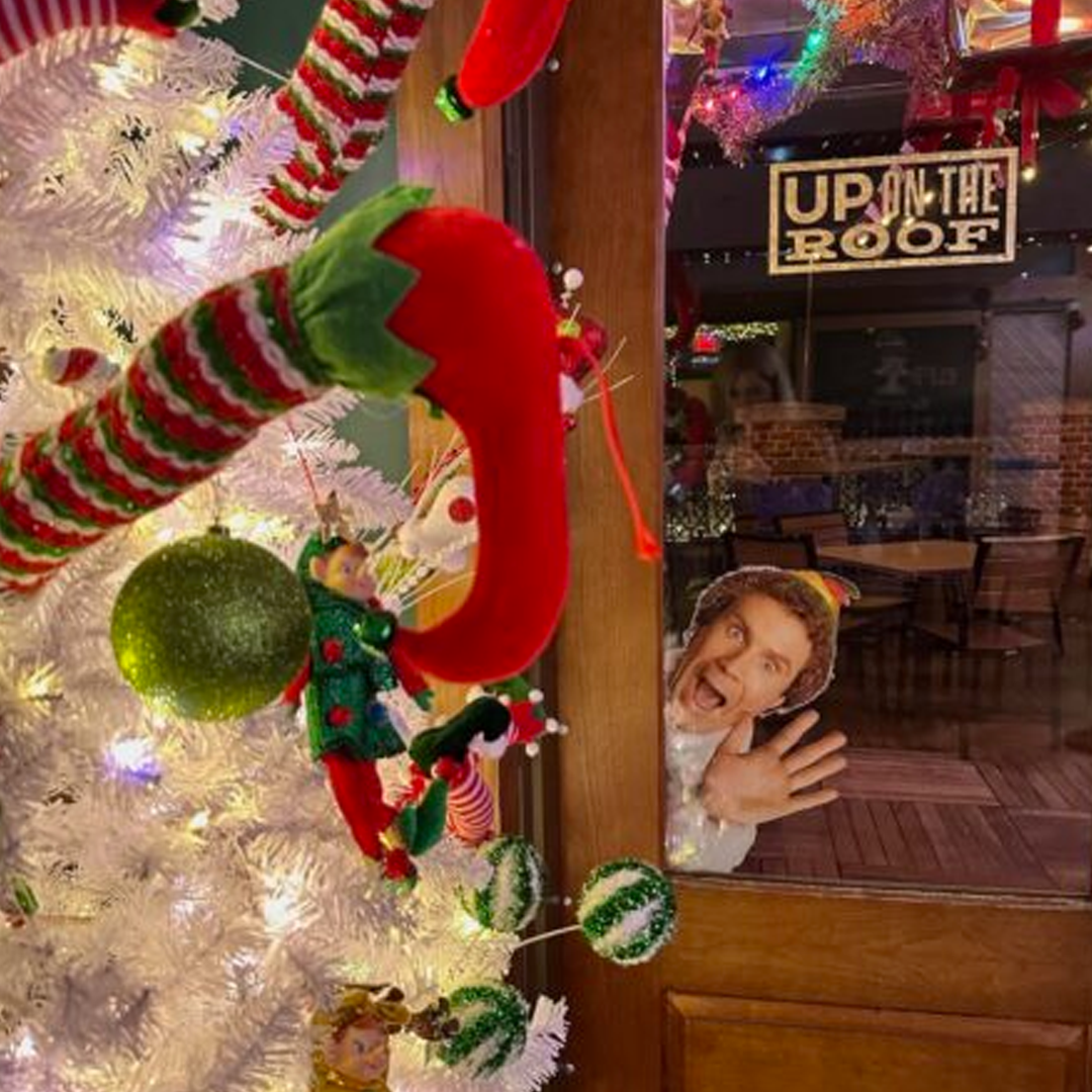 ELF peeking through the Alpharetta window at UP on the Roof Alpharetta Elf'd UP holiday pop-up